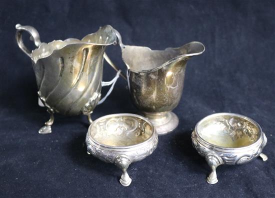 A pair of George III silver bun salts and two silver cream jugs.